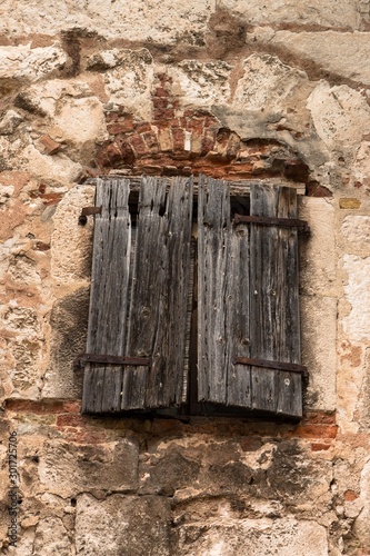 Old wooden window on a stone house photo