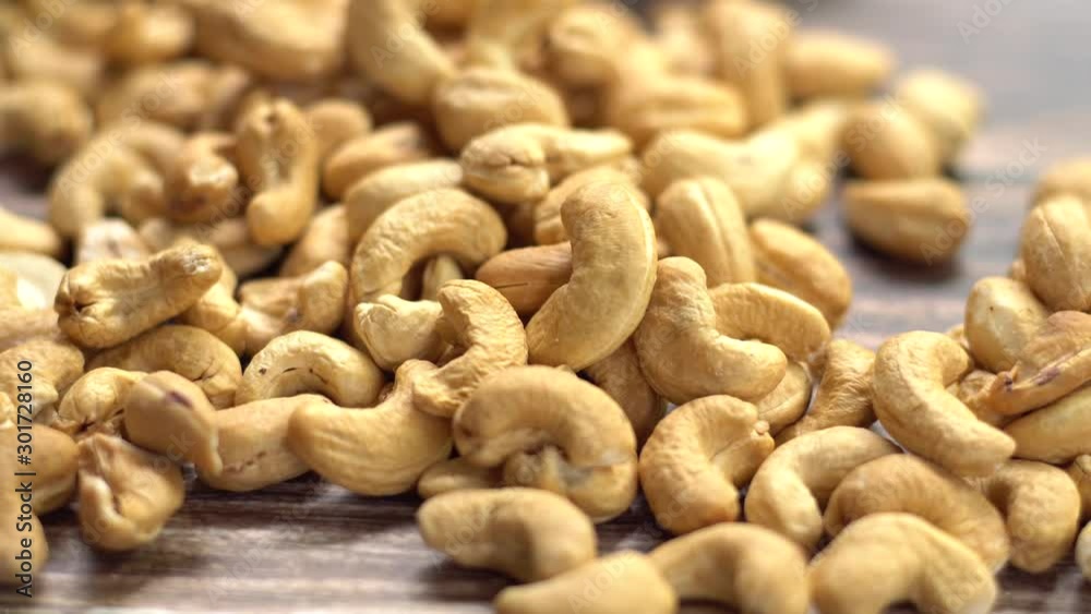 Still life of toasted cashew nuts on table, Shot in studio, movement camera, selective focus and free space for text. Good healthy food ideas concept. Still life of toasted cashew nuts on table, Shot in studio, movement camera, selective focus and free space for text. Good healthy food ideas concept.