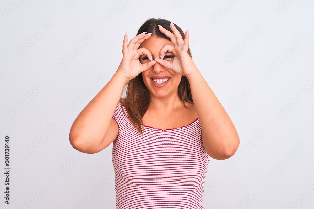 Portrait of beautiful young woman standing over isolated white background doing ok gesture like binoculars sticking tongue out, eyes looking through fingers. Crazy expression. Portrait of beautiful young woman standing over isolated white background doing ok gesture like binoculars sticking tongue out, eyes looking through fingers. Crazy expression.