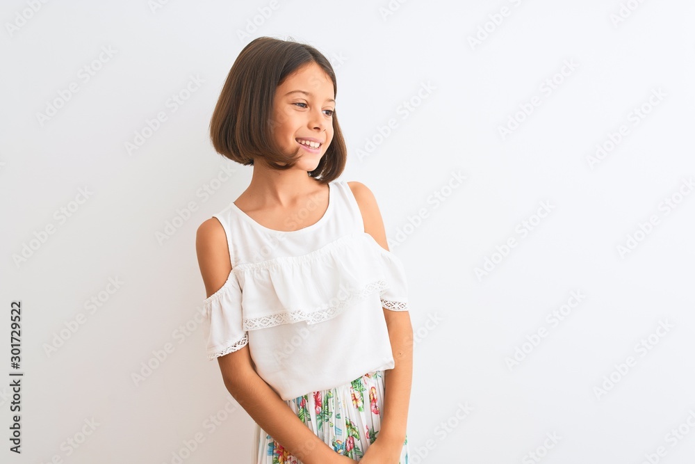Young beautiful child girl wearing casual dress standing over isolated white background looking away to side with smile on face, natural expression. Laughing confident. Young beautiful child girl wearing casual dress standing over isolated white background looking away to side with smile on face, natural expression. Laughing confident.