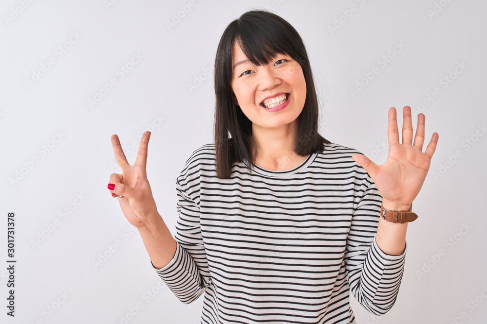 Young beautiful chinese woman wearing black striped t-shirt over isolated white background showing and pointing up with fingers number seven while smiling confident and happy. Young beautiful chinese woman wearing black striped t-shirt over isolated white background showing and pointing up with fingers number seven while smiling confident and happy.