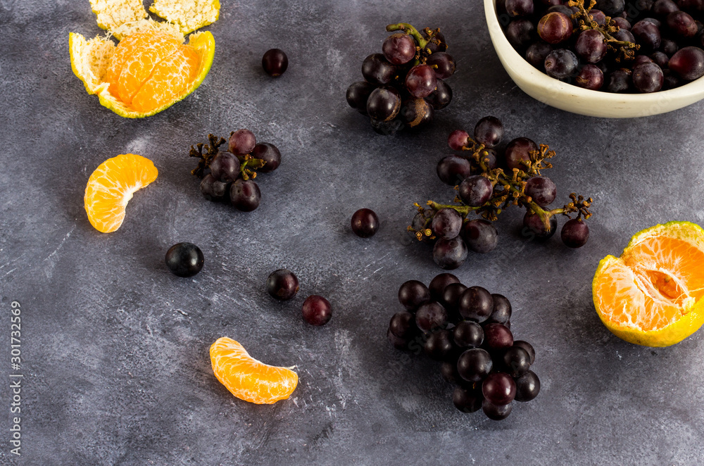 Scattered Grapes and Oranges on Dark Background High Angle Photo. Healthy Raw Food Photography.