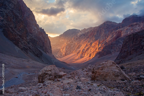 Martian landscape in mountains of Tajikistan, Pamir-Alay. Sun illuminates of rock wall on sunset in canyon of Fann mountains