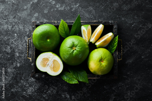 Sweetie green citrus fruit in wooden box.Top view. photo
