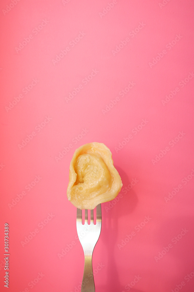 Dumplings on a fork, pink background Dumplings on a fork, pink background