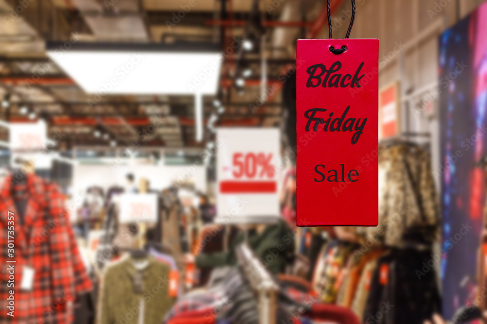 Black friday on a red tag against the background of a shopping mall hyper mall on the day of sales and promotions
