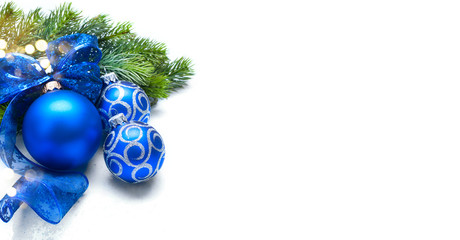 Blue Christmas and New Year Decoration isolated on white background. Border art design with holiday baubles. Beautiful Xmas tree closeup decorated with balls, tinsel, ribbon. Space for text
