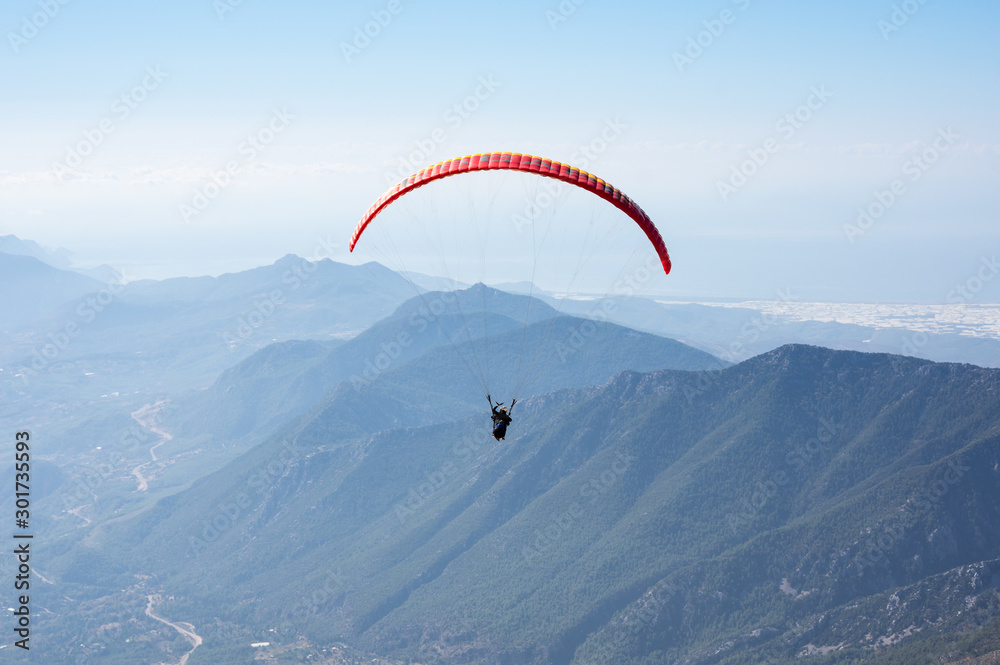 Paraglider flying over mountains Paraglider flying over mountains