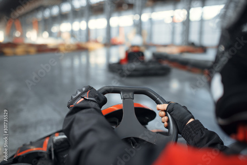 Racer in helmet driving go kart car