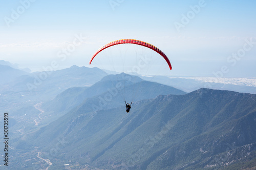 Paraglider flying over mountains