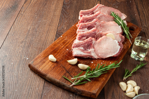 Fresh steak loin of raw meat and spices and a knife lies on a wooden background. copy space
