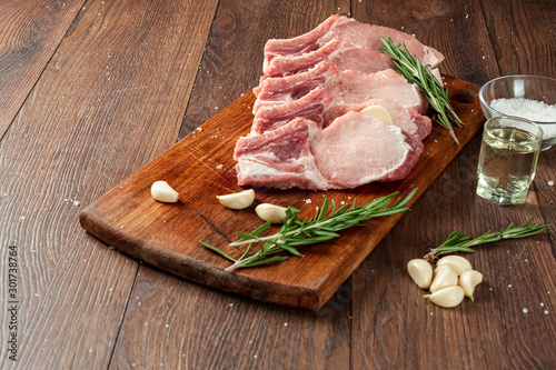 Fresh steak loin of raw meat and spices and a knife lies on a wooden background. copy space