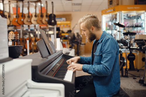 Musician trying to play on piano in music store