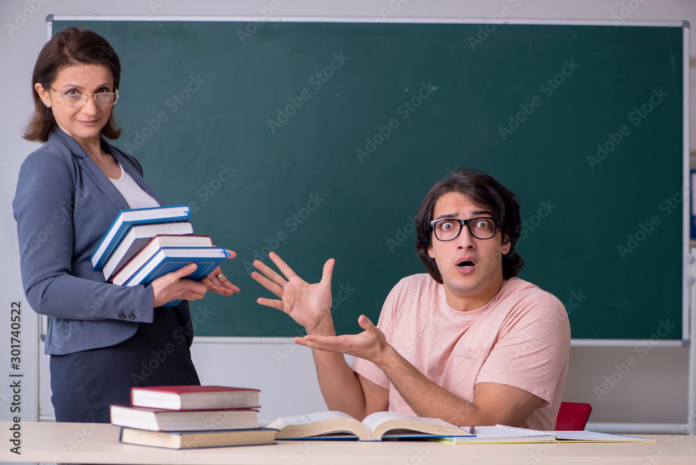 Old female teacher and male student in the classroom Old female teacher and male student in the classroom