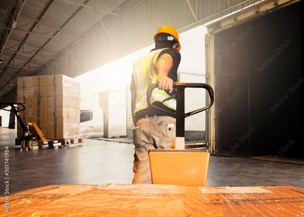 Warehouse worker unloading pallet shipment boxes into cargo container. Pakage boxes. Shipping warehouse logistics. Freight truck transportation. - obrazy, fototapety, plakaty 