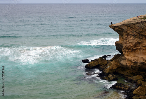 Fisher man on a cliff near Praia de Monte Clerigo, Alentejo, Portugal