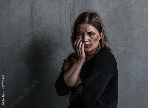 Depressed woman victim of domestic violence and abuse. Empty space for text photo