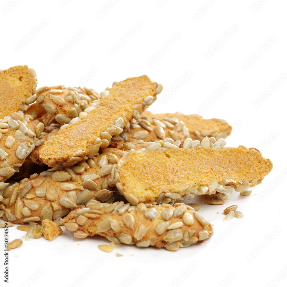 A broken breadstick with sunflower seeds and crumbs on white background A broken breadstick with sunflower seeds and crumbs on white background