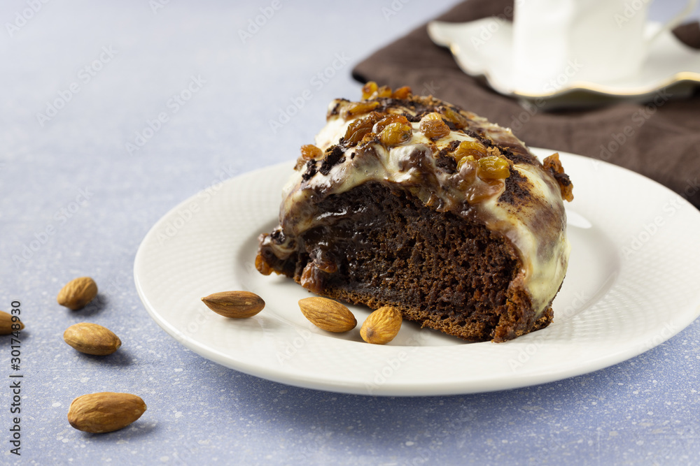 Delicious chocolate cake with raisins and cream. Piece of Chocolate Cake on a Plate. Sweet food. Sweet dessert. Light bakcground. Close up. Delicious chocolate cake with raisins and cream. Piece of Chocolate Cake on a Plate. Sweet food. Sweet dessert. Light bakcground. Close up.