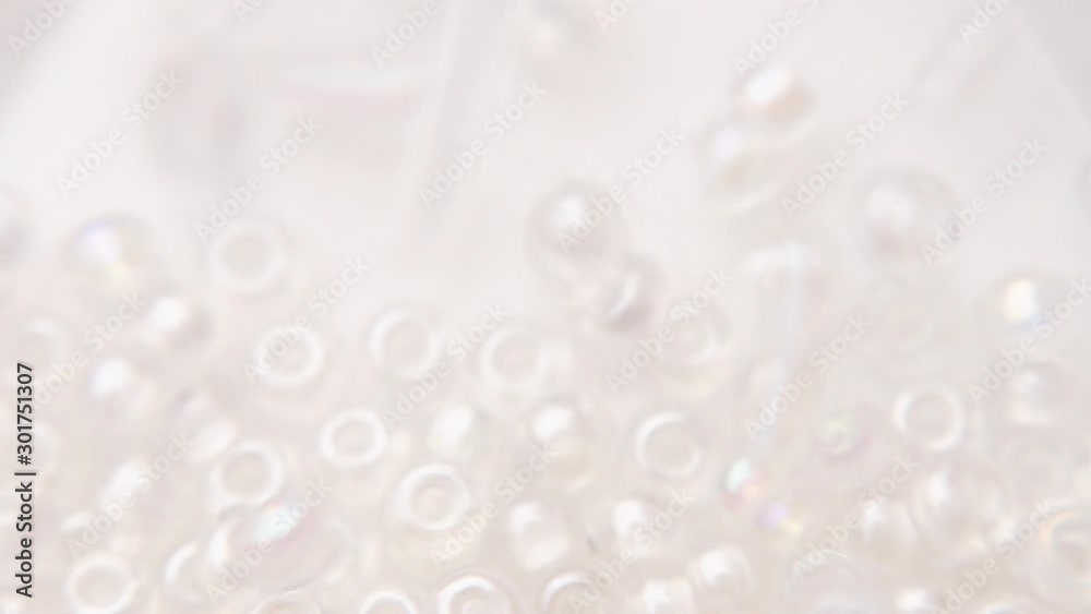 Pouring a white transparent bead bag in a store. Pouring a white transparent bead bag in a store.