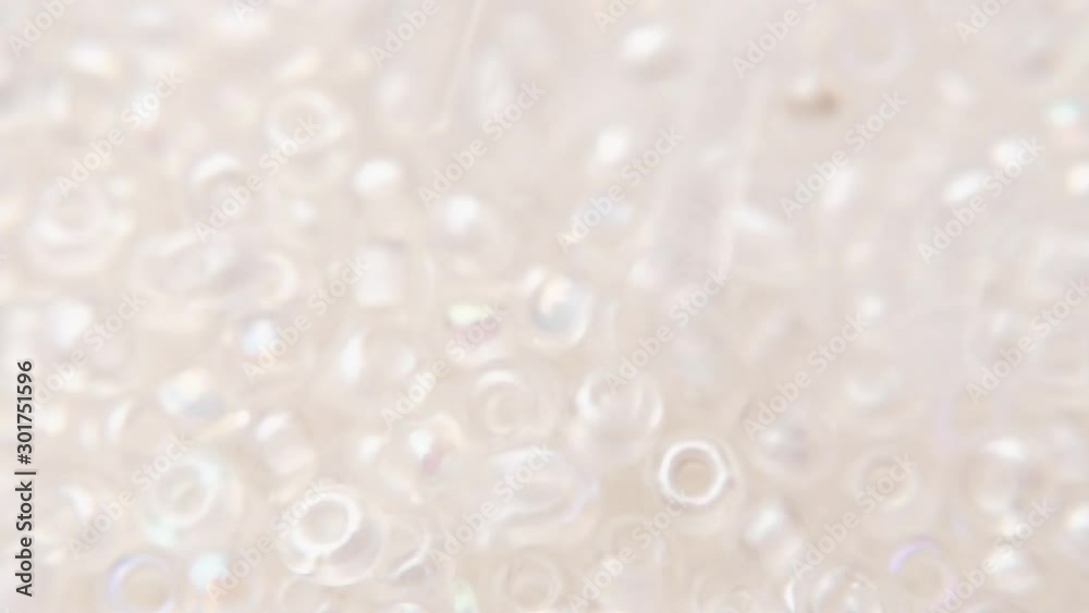 Pouring white transparent beads into a plate. Pouring white transparent beads into a plate.