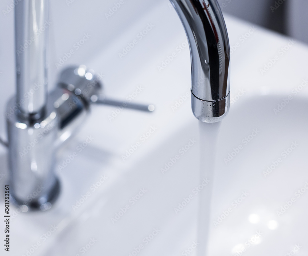 Saving water: Close up of spigot with clear, flowing water Saving water: Close up of spigot with clear, flowing water