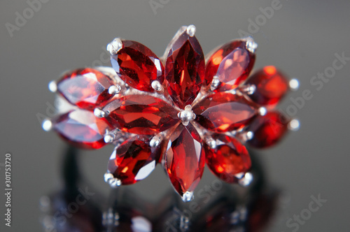 Φωτογραφία beautiful vintage ring with garnet stones as flower on black background