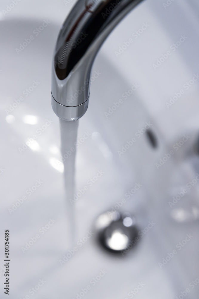 Saving water: Close up of spigot with clear, flowing water Saving water: Close up of spigot with clear, flowing water