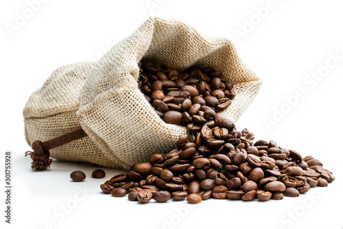 Roasted coffee beans scattered of the burlap bag isolated on white