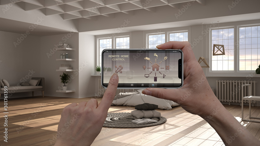 Remote home control system on a digital smart phone tablet. Device with app icons. Interior of minimalist bedroom with bed and decors in the background, architecture design Remote home control system on a digital smart phone tablet. Device with app icons. Interior of minimalist bedroom with bed and decors in the background, architecture design