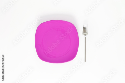 Empty Fuchsia color plate and fork next to it. Isolated object - on white background