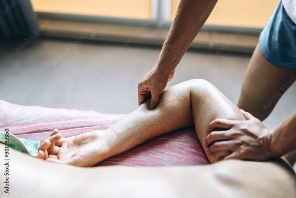 Obraz premium A woman physiotherapist doing back massage for a man in the medical office. Closeup of warm-up of the patient's hand