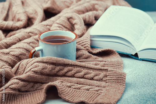 Photography Сup of hot tea, open book and warm knitted blanket