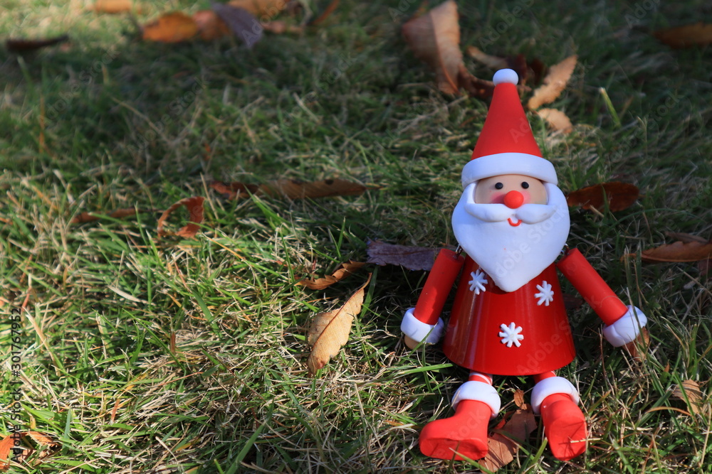 Obraz premium クリスマスのひと月前 秋の空を見上げてほほ笑むサンタクロース