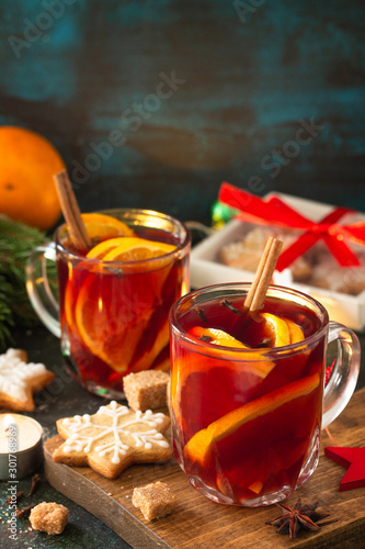 Winter Christmas mulled wine with orange and spices on the festive table. Copy space.