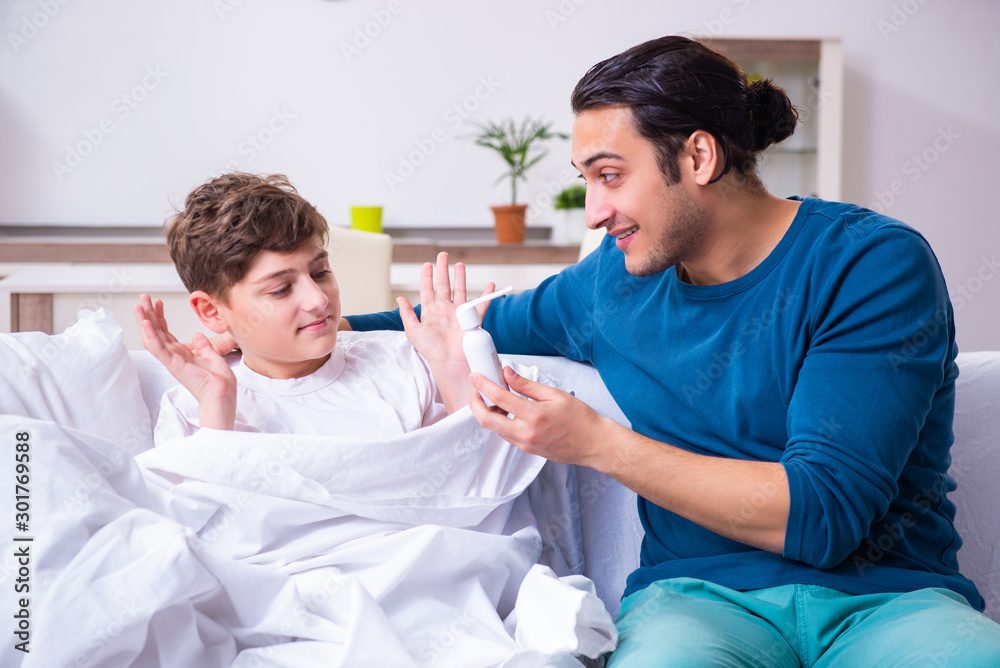 Fototapeta premium Young father caring for sick son