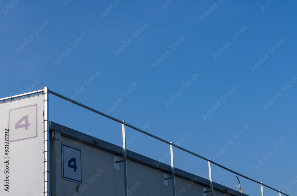 Number four (4) on the business building, big industrial building with number four on the top and a blue sky background - Image Number four (4) on the business building, big industrial building with number four on the top and a blue sky background - Image