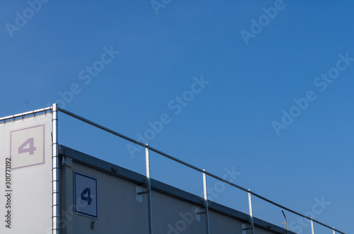 Number four (4) on the business building, big industrial building with number four on the top and a blue sky background - Image