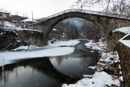 View of the traditional stone bridge in Vovousa village in Epirus, Greece in winter photo