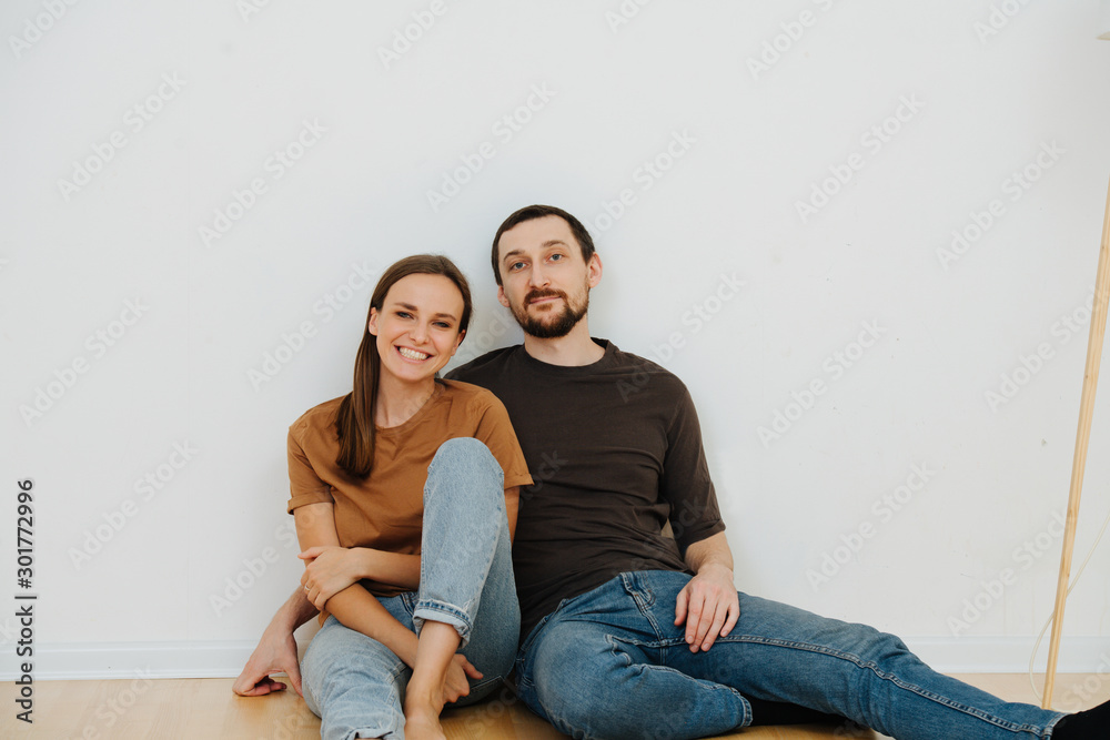 Portrait of a middle age couple sitting on the floor of the new apartment Portrait of a middle age couple sitting on the floor of the new apartment