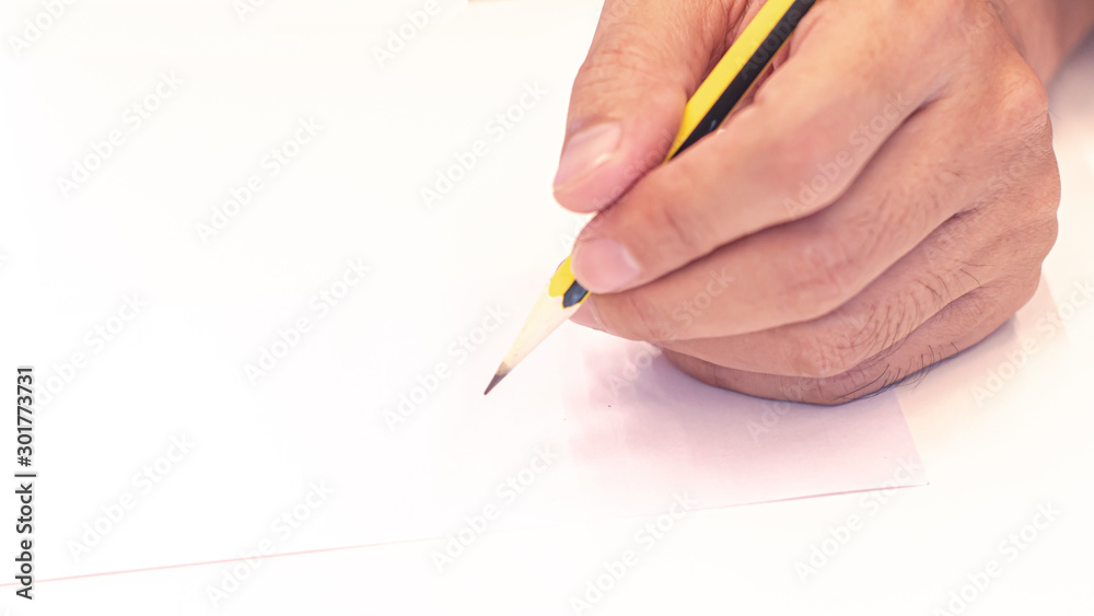 hand holding a pencil isolated on white background . Close Up on a man's hand writing on paper with a pencil .Planning business idea background . leave note or message concept. hand holding a pencil isolated on white background . Close Up on a man's hand writing on paper with a pencil .Planning business idea background . leave note or message concept.