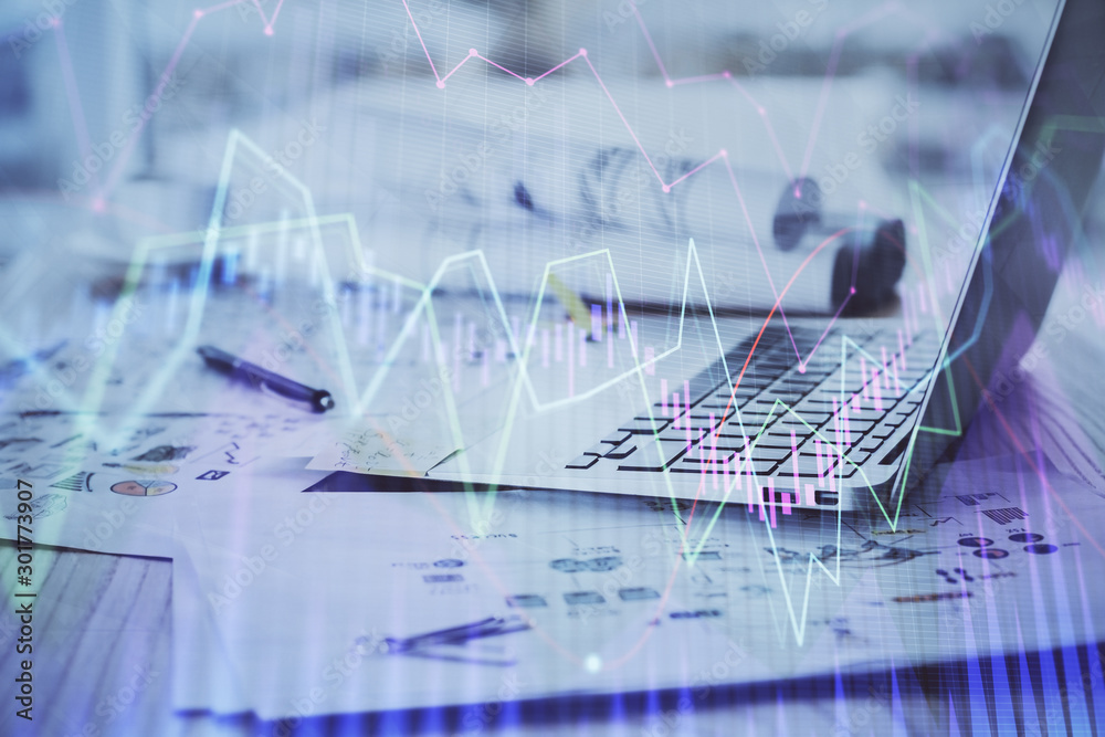 Forex Chart hologram on table with computer background. Double exposure. Concept of financial markets. Forex Chart hologram on table with computer background. Double exposure. Concept of financial markets.