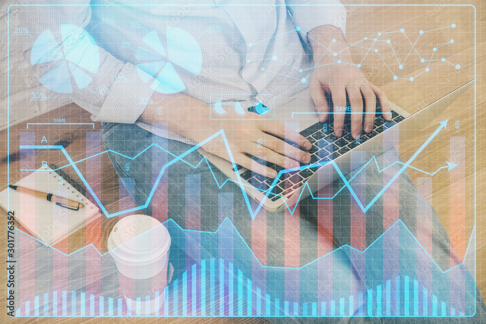 Double exposure of man's hands writing notes with laptop of stock market with forex graph background. Top View. Concept of research and trading. Double exposure of man's hands writing notes with laptop of stock market with forex graph background. Top View. Concept of research and trading.