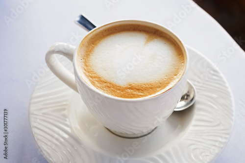 A cup of fresh cappuccino in caffe close-up