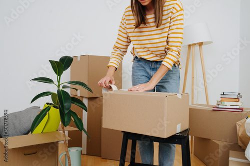 Cropped image of a woman packing, she's moving out from old apartment. photo