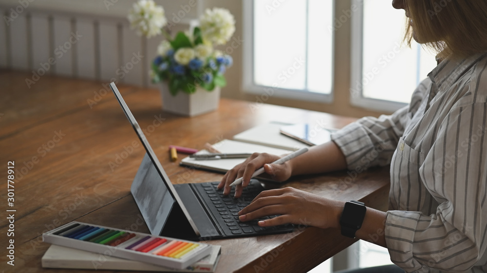 Fototapeta premium Closeup young female typing digital tablet.