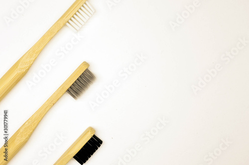 Black and white bamboo toothbrush on white background. Tooth care hygiene.  © Alona