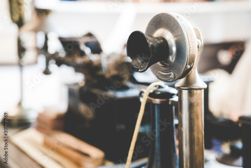 Old vintage antique candlestick telephone on the business working table working on the past. Candle stick phone sitting on a desk top.