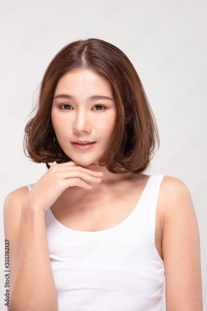 Beautiful Young Asian Woman with short hair Looking While Touching Chin feeling so happy and cheerful with healthy Clean and Fresh skin,isolated on gray background,Beauty Cosmetics Concept Beautiful Young Asian Woman with short hair Looking While Touching Chin feeling so happy and cheerful with healthy Clean and Fresh skin,isolated on gray background,Beauty Cosmetics Concept
