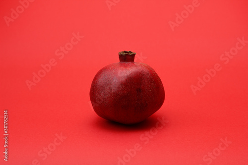 Red ripe pomegranate on a red background close-up.Juicy healthy fruit. Food for vegetarians. Health nutrition.